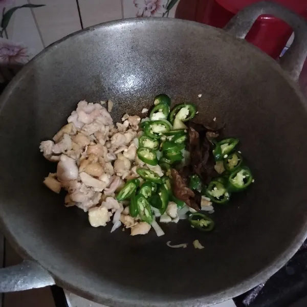 Taruh kulit ayam di pinggiran, gunakan minyak untuk menumis bawang merah, bawang putih, bawang bombay, cabai dan daun salam hingga harum lalu aduk rata.