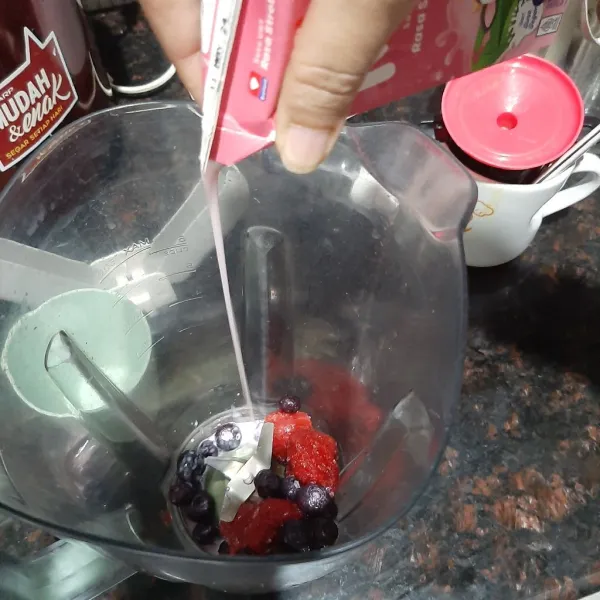 Masukkan buah dan susu ke dalam blender.