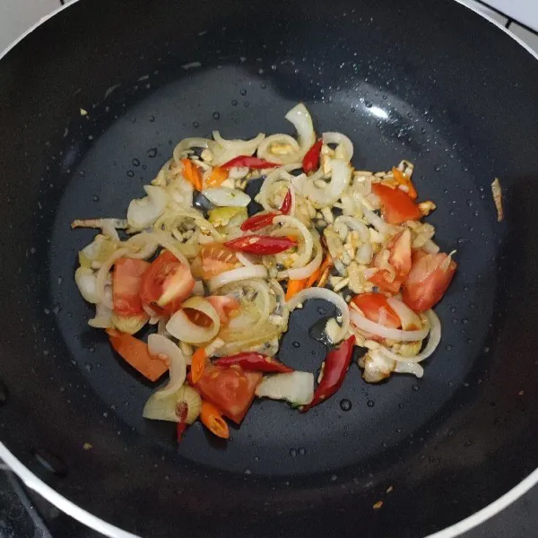 Tumis bawang putih dan bawang bombay hingga layu, masukkan cabe merah, cabe rawit dan tomat. Aduk-aduk dan masak sebentar.