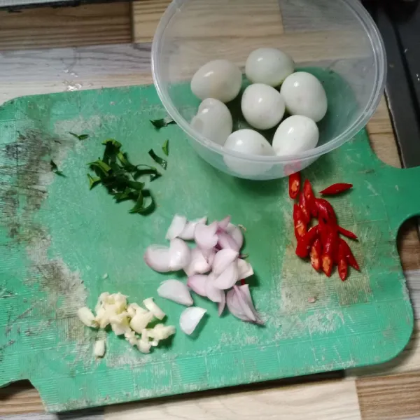 Iris bawang merah, bawang putih, daun jeruk dan cabe merah keriting.