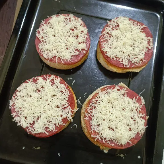Letakkan beef slice di atas roti burger bagian yang bawah, lalu taburi dengan keju quick melt mozarella parut, kemudian panggang hingga meleleh.