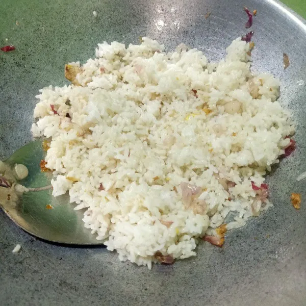 Iris duo bawang lalu oseng di wajan sampai tercium harum. Lalu masukkan nasi putih.