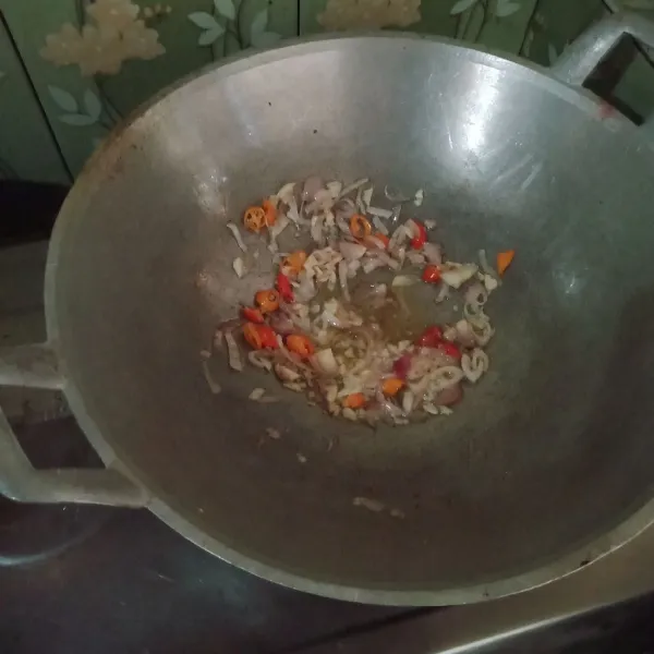 Tumis bawang merah, bawang putih, cabe rawit, dan cabe merah hingga harum.