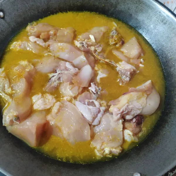 Masukkan ayam bersama bumbu, garam dan juga air ke dalam wajan.