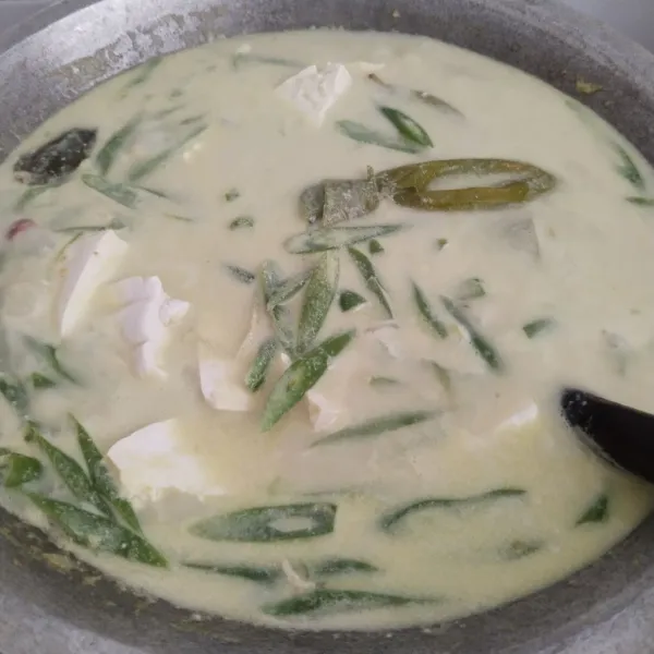 Masak sampai santan mendidih, kemudian masukkan tahu dan buncis kemudian aduk rata.