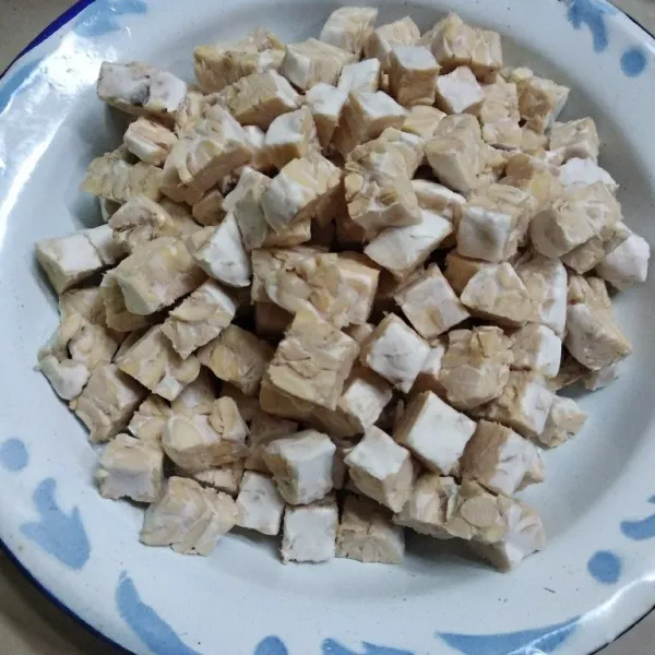 Potong dadu tempe dan iris bakso dengan ketebalan sesuai selera. Iris tipis-tipis bawang merah, bawang putih dan cabai.