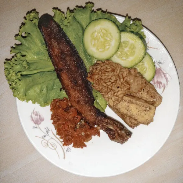 Sajikan dengan timun dan selada. Pecel lele siap disantap.