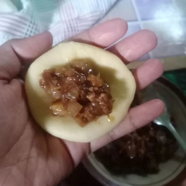 Ambil 1 adonan, pipihkan. Isi dengan 1 sdm isian daging. Kemudian bulatkan.