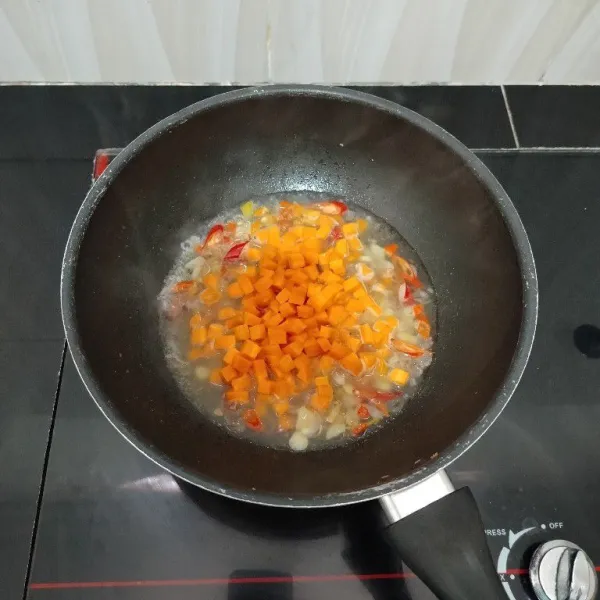 Lalu masukkan wortel, aduk rata. Masak hingga wortel matang dan air menyusut.