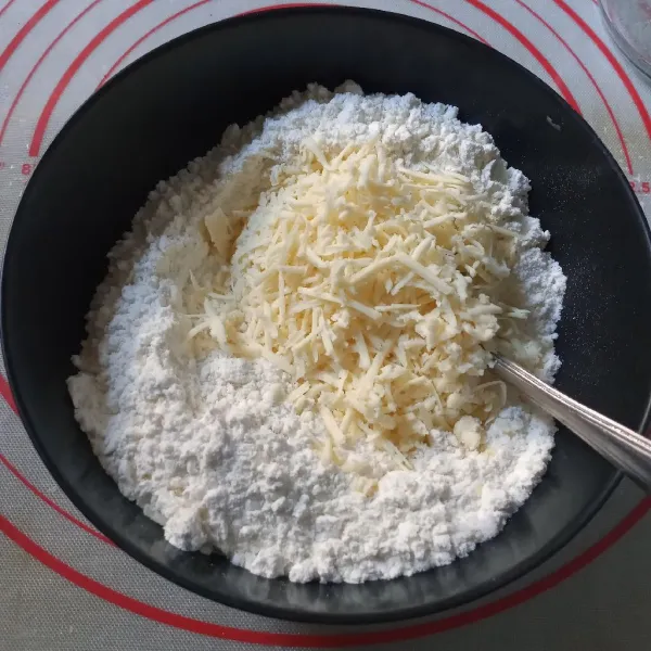 Dalam mangkuk campur tepung terigu, gula, baking powder, baking soda, dan keju, lalu aduk rata