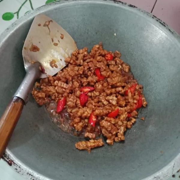 Masukkan tempe, kecap manis, garam, penyedap, dan gula lalu aduk rata kemudian masukkan cabe merah. Terakhir tambahkan air agar bumbu merata, aduk dan masak sampai bumbu meresap. Setelah matang, angkat tuang ke piring saji dan siap disajikan