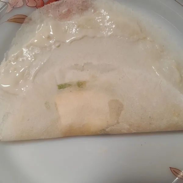 Beri pinggiran kulit lumpia tepung basah lalu lipat seperti amplop.