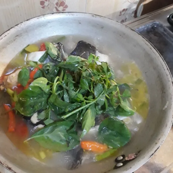 Setelah ikan matang dan mendidih, masukkan daun kemangi dan perasan jeruk lemon, aduk sebentar lalu matikan kompor. Sup ikan patin siap disajikan.