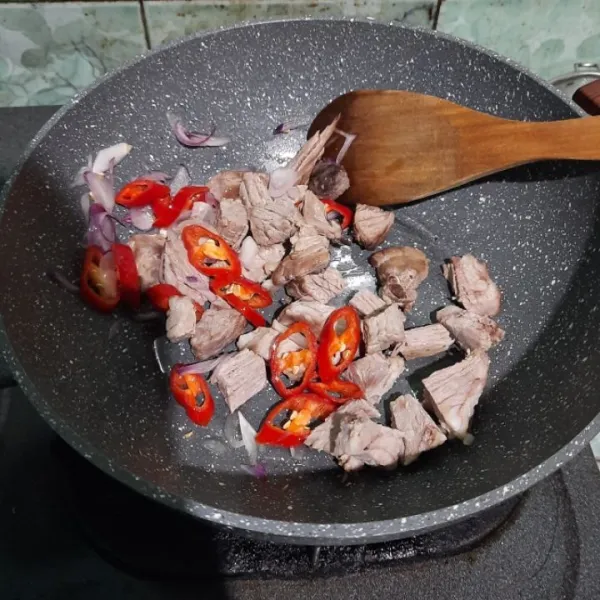 Panaskan minyak goreng lalu tumis bawang merah, cabai merah, dan daging tumis hingga harum.