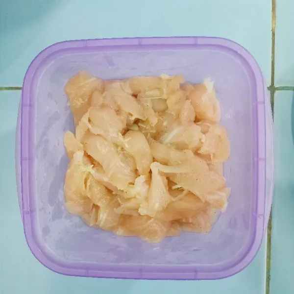 Marinasi ayam dengan bawang putih parut dan merica.