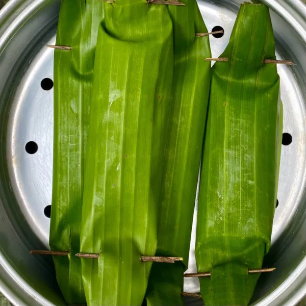 Gulung daun pisang, lalu beri lidi di kedua sisi. Kukus selama 30 menit, angkat dan sisihkan.