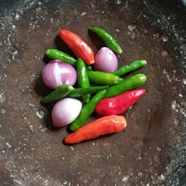 Siapkan cobek, haluskan bawang merah, bawang putih, cabe rawit, dan garam.