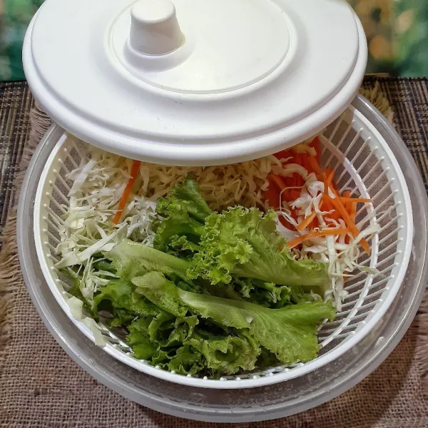 Letakkan sayuran di wadah salad spinner dan putar salad spinner hingga sayuran kering. Jika tidak punya salad spinner maka sayuran cukup ditiriskan hingga kering.