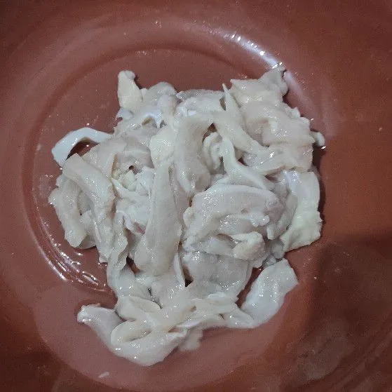 Potong daging ayam memanjang lalu cuci bersih dan tiriskan.
