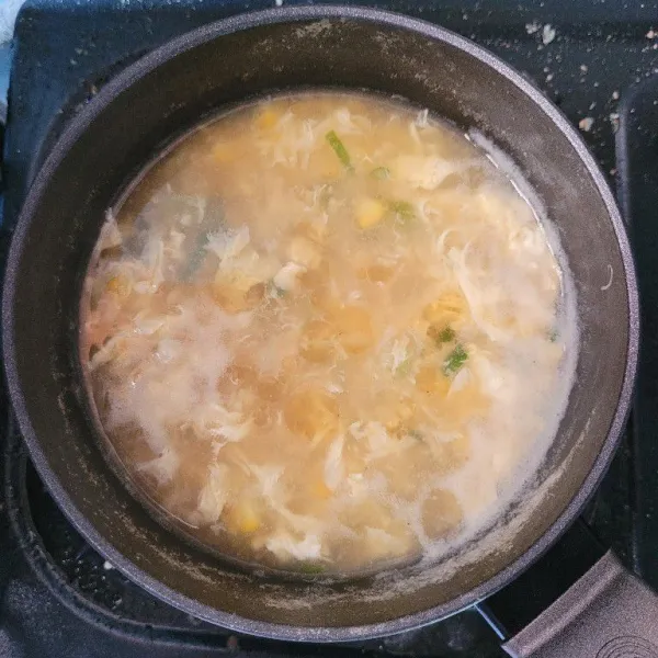 Matikan kompor dan tuang minyak wijen kedalam sup, sup jagung telur siap dihidangkan.
