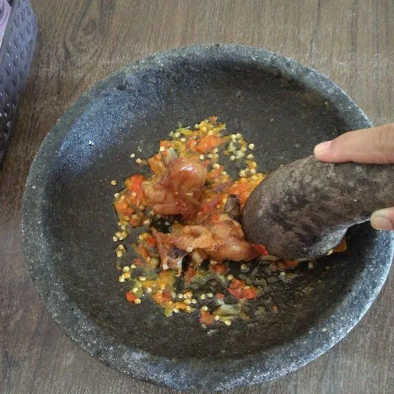 Penyet ayam goreng di atas sambal. Tata nasi, lalapan, ayam penyet di piring. Siap disajikan.