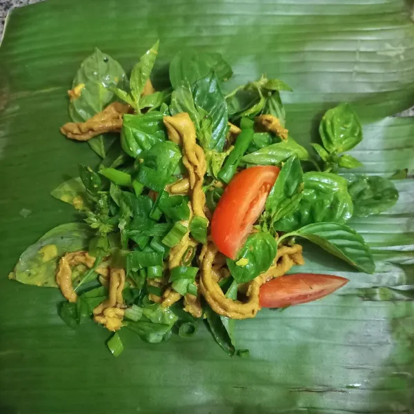 Siapkan daun pisang, tuang usus ayam tambahkan daun kemangi, bawang daun dan irisan tomat, lipat daun dan rapihkan.