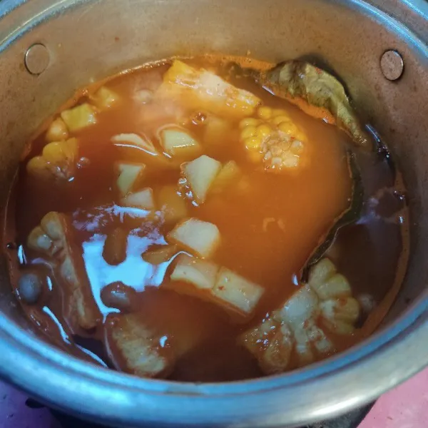 Masukkan jagung manis dan labu siam, aduk dan masak hingga setengah matang.