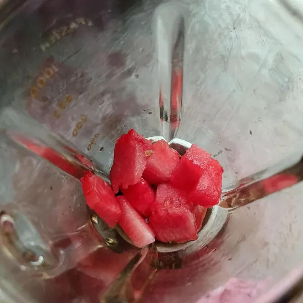 Potong-potong semangka dan masukkan ke dalam blender.