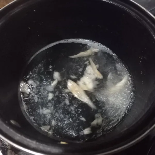 Didihkan air, masukkan ikan asin dan bawang putih masak sebentar saja.