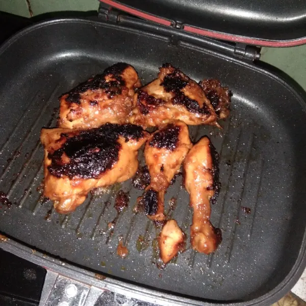 Letakkan potongan ayam di atas panggangan yang telah dioles mentega. Panggang hingga berubah warna. Setelah itu angkat dan sisihkan.