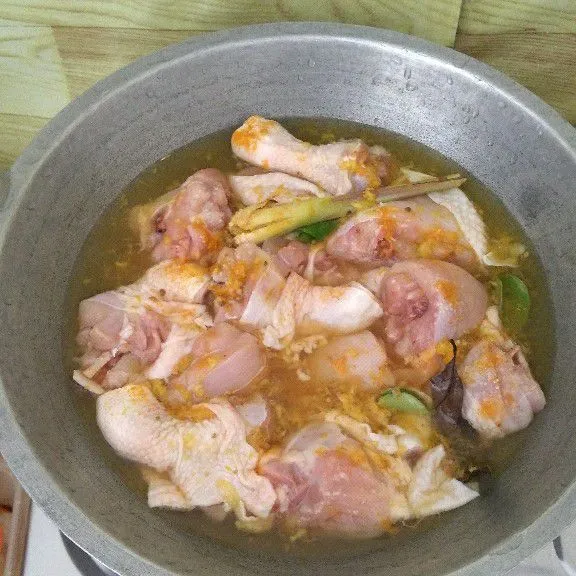 Masukkan ayam, daun jeruk, daun salam, serai, air, kaldu jamur, garam di wajan kemudian aduk.