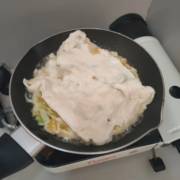 Panaskan pan, beri minyak, masukan telur, kemudian timpa dengan adonan, masak hingga kedua sisi garing.