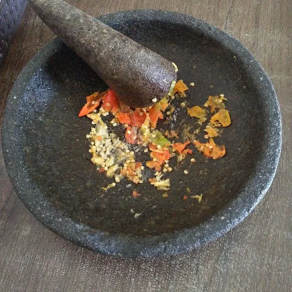 Haluskan cabe, bawang putih, garam, kaldu jamur, dan gula pasir. Siram sambal dengan sedikit minyak goreng panas.
