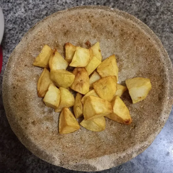 Masukkan kentang yang telah digoreng, haluskan bersama bawang putih.