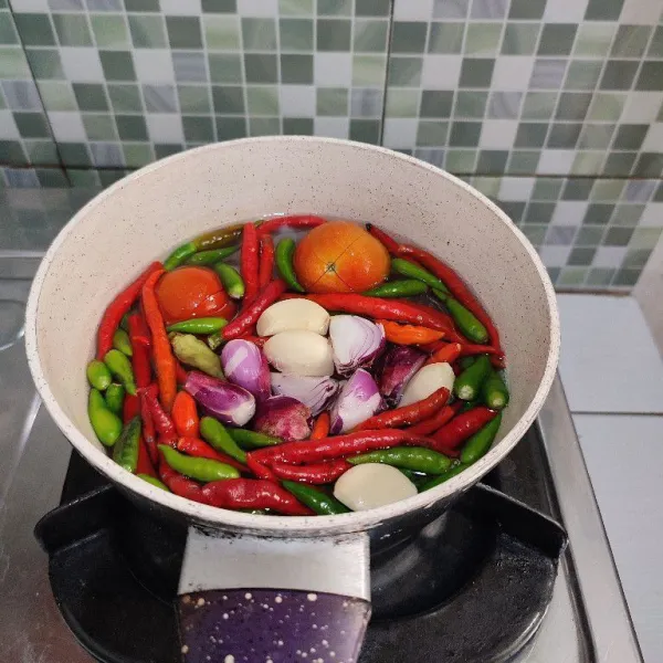 Rebus cabe, tomat, bawang merah, dan bawang putih hingga layu. Kemudian tiriskan.