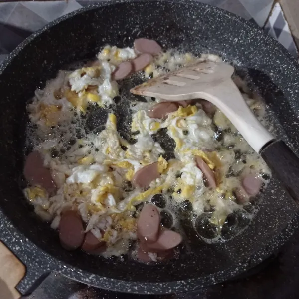 Buat telur orak-arik, masukkan bawang putih dan sosis. Masak sampai matang