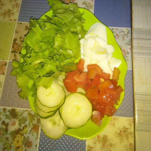 Potong daun selada, iris tipis putih telur dan timun. Potong dadu tomat. Sisihkan dahulu