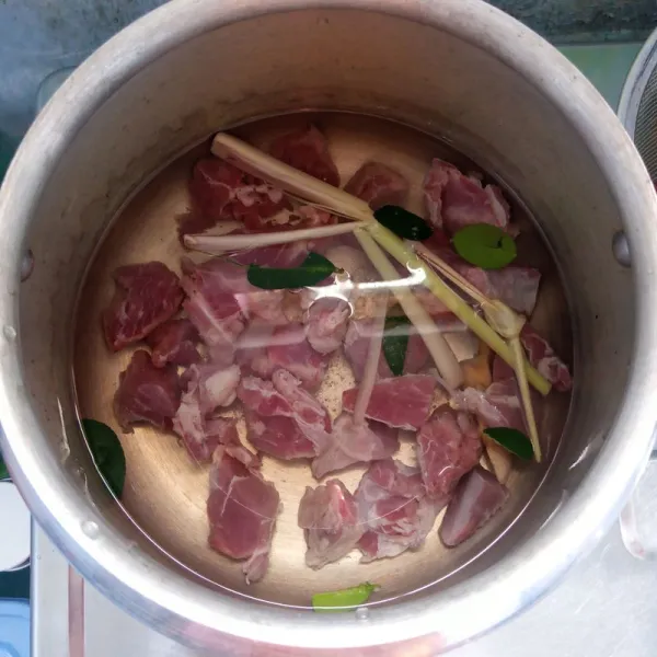 Presto daging bersama serai, daun jeruk dan jahe sampai empuk.