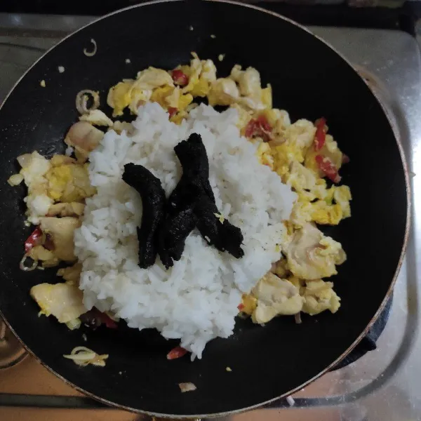 Masukkan nasi dan bumbu rawon lalu aduk rata.