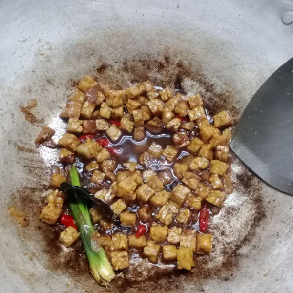 Masukkan tempe, aduk rata. Tuang air. Bumbui dengan garam, gula merah dan kecap. Masak sampai meresap. Angkat.