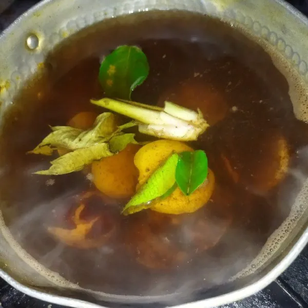 Masak air secukupnya hingga mendidih, lalu masukkan bubuk kopi, daun salam, serai, daun jeruk dan jengkol, rebus hingga jengkol empuk.