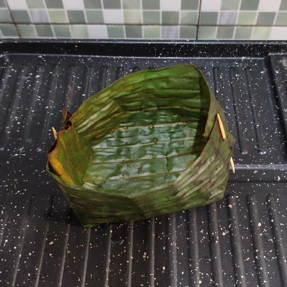 Siapkan saun pisang, buat seperti perahu.