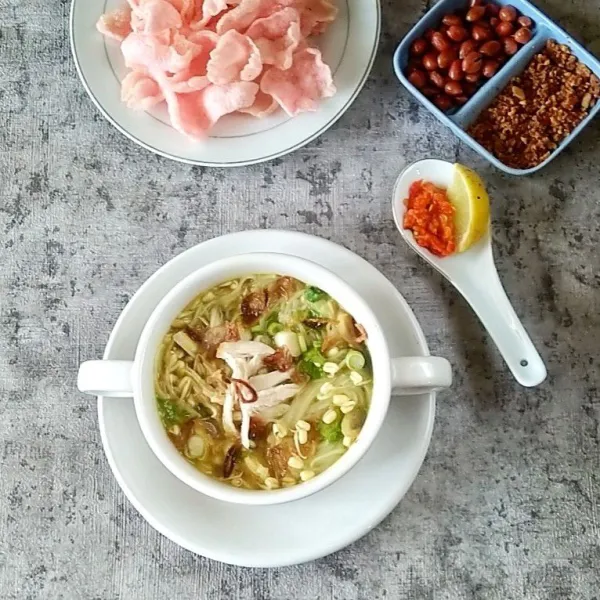 Dalam wadah mangkuk, tata soun, kubis, suwiran ayam dan toge pendek. Kemudian siram kuah soto. Taburi dengan irisan daun bawang dan bawang merah goreng. Sajikan selagi hangat dengan kerupuk merah, bubuk kacang tanah, sambal dan irisan jeruk nipis.