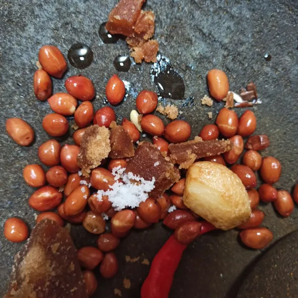 Siapkan bumbu kacang, letakkan di cobek, kecuali air. Lalu ulek, kemudian beri air hangat perlahan sambil diaduk. Untuk rasanya sesuaikan.
