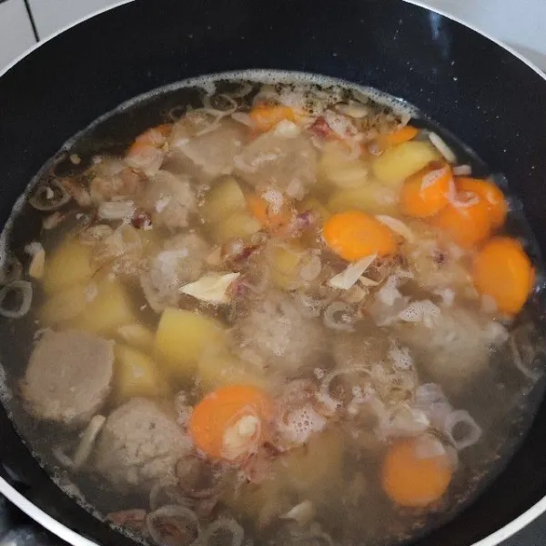 Tuang 700 ml air, masak hingga air mendidih. Tambahkan kentang, wortel dan bakso. Masak kembali hingga wortel dan kentang sedikit lembut.