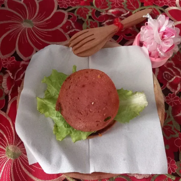 Masukkan daging ham yang telah digoreng, lalu tutup dengan roti burger di atasnya.
