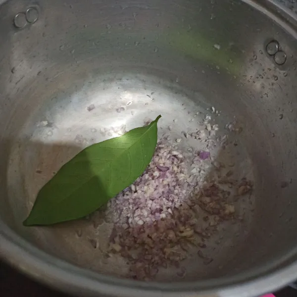 Tumis bumbu giling bersama daun salam dan laos hingga harum.