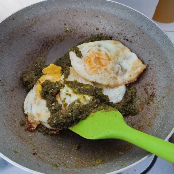 Masukkan telur ceplok, aduk rata dengan bumbu.