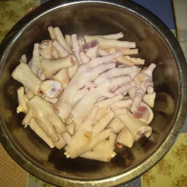 Bersihkan ceker ayam dari kulit luarnya dan potong kuku-kukunya. Potong kaki ayam menjadi dua bagian jika dirasa besar.