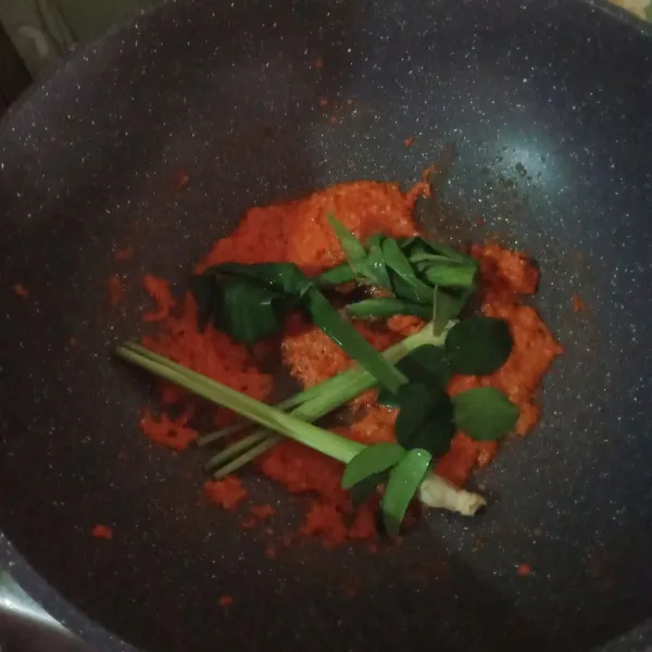 Tumis bumbu halus dan daun bawang hingga harum masukkan daun jeruk, lengkuas, serai, daun pandan, dan daun kunyit tumis kembali.